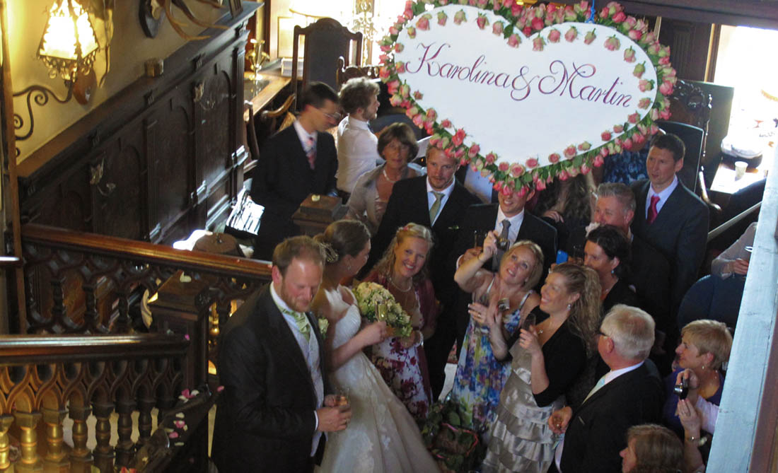 Brudpar och bröllopsgäster i hallen på Rockelstad Slott