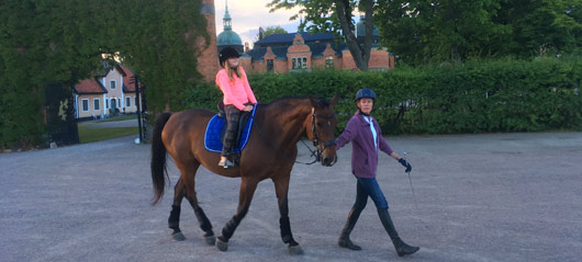 Ridtur barn med häst framför slottet